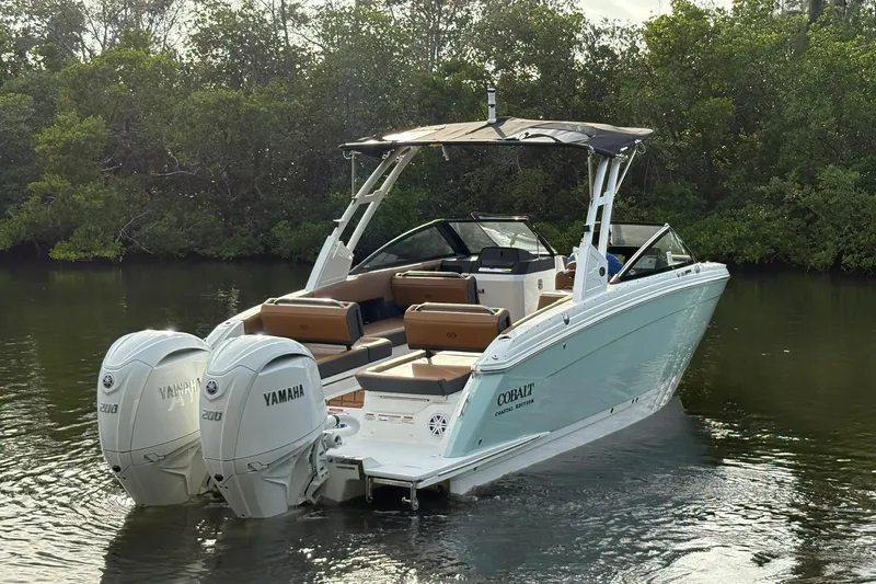 Slide: The Image of 2026 Cobalt R8 Outboard boat with dual Yamaha engines on a calm waterway. - 5