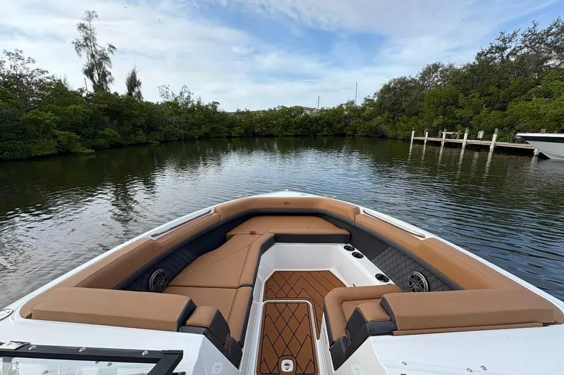 Slide: The Image of 2026 Cobalt R8 Outboard boat with tan seating, docked in a serene waterway. - 8