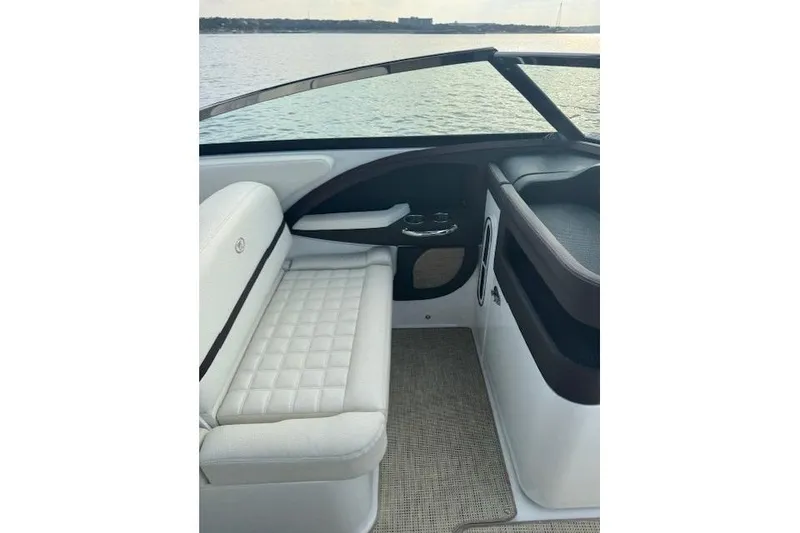 Slide: The Image of 2017 Cobalt R30 boat interior with white seating and cup holders, overlooking calm water. - 5