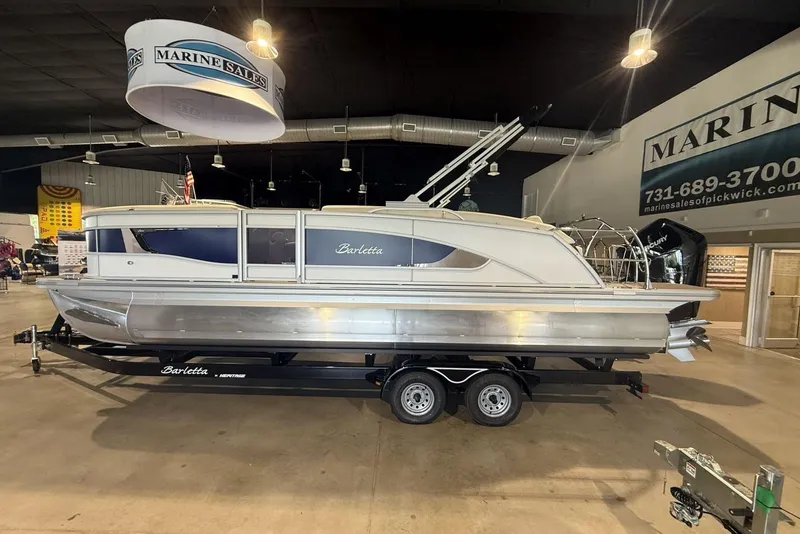 The Image of 2026 Barletta Lusso 23U pontoon boat displayed indoors on a trailer. - 1