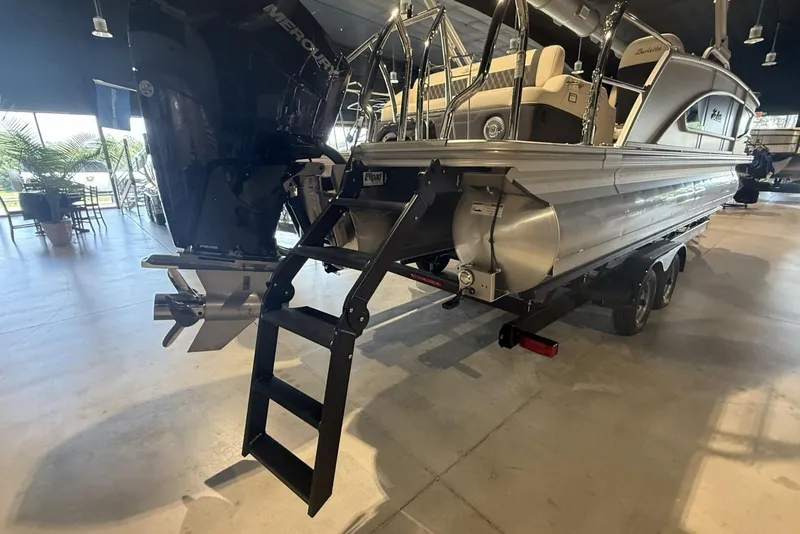 Slide: The Image of 2026 Barletta Lusso 23U pontoon boat with Mercury engine and ladder, displayed indoors. - 13
