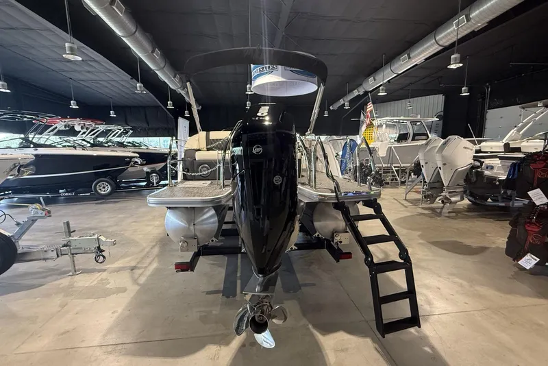 Slide: The Image of 2026 Barletta Lusso 23U pontoon boat displayed in a showroom with other boats. - 15