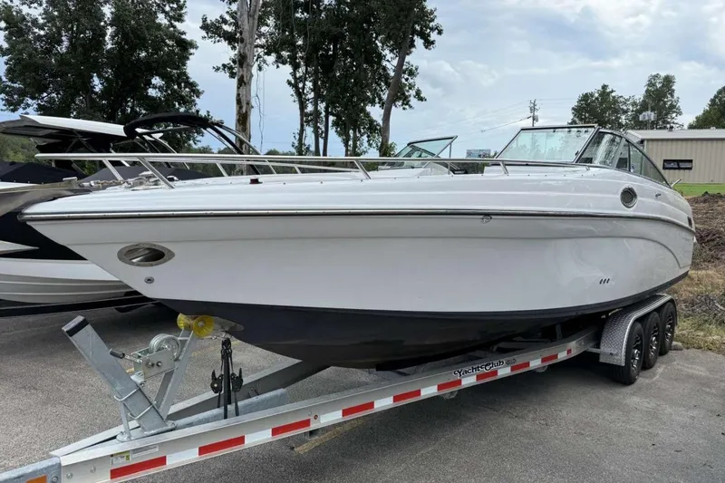 The Image of 2005 Crownline 288 BR boat on trailer, parked outdoors with trees in background. - 0