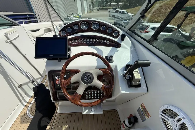 Slide: The Image of 2005 Crownline 288 BR boat dashboard with wooden steering wheel and control panel. - 13