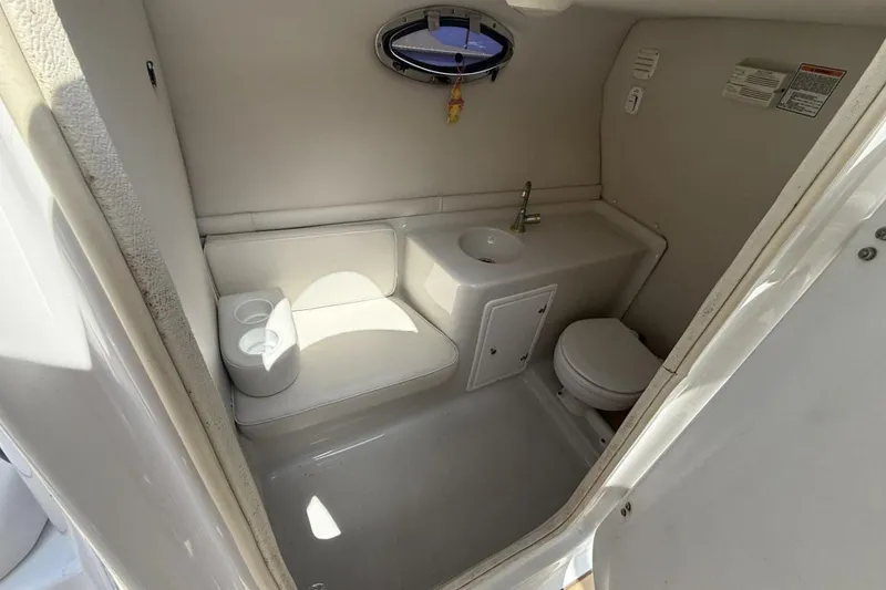 Slide: The Image of 2005 Crownline 288 BR boat bathroom with sink, toilet, and small window. - 14