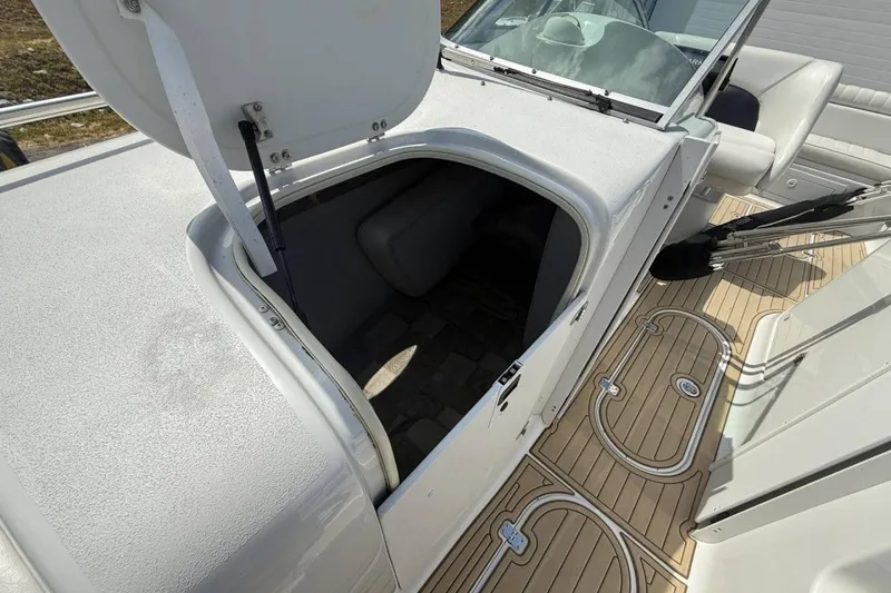 Slide: The Image of 2005 Crownline 288 BR boat with open storage compartment and teak-style flooring. - 16