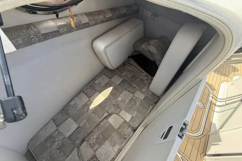 Slide: The Image of 2005 Crownline 288 BR cabin interior with patterned cushions and compact design. - 17