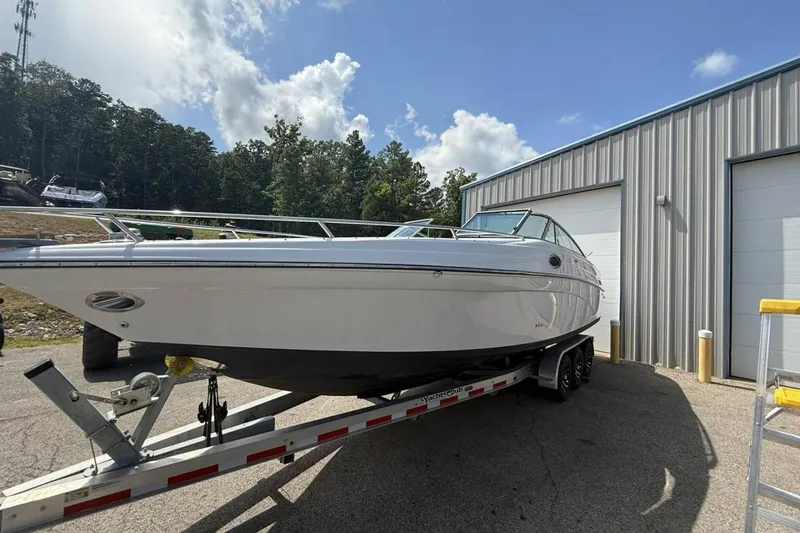 Slide: The Image of 2005 Crownline 288 BR boat on trailer near metal building under blue sky. - 26