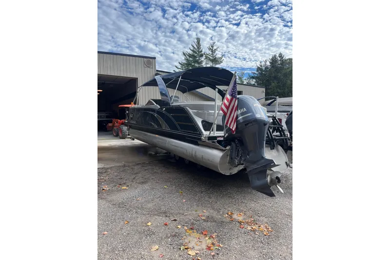Slide: The Image of 2021 Bennington 27 QXFBWAX2 pontoon boat with Yamaha engine, parked outdoors. - 21