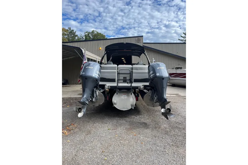 Slide: The Image of 2021 Bennington 27 QXFBWAX2 boat with dual Yamaha 250 engines, parked outdoors. - 24