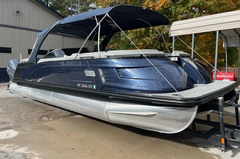 Slide: The Image of 2021 Bennington 27 QXFBWAX2 pontoon boat with blue exterior, docked outdoors. - 26
