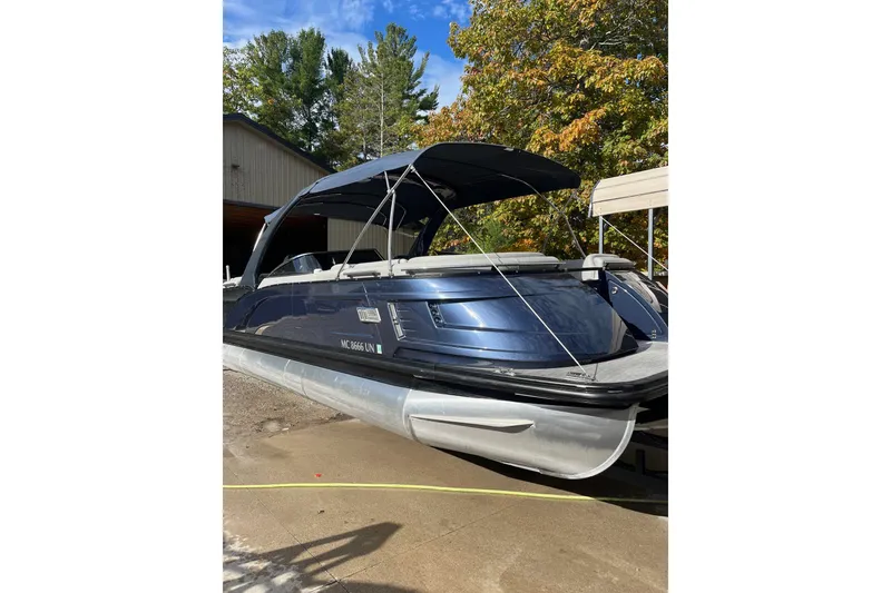 Slide: The Image of 2021 Bennington 27 QXFBWAX2 pontoon boat with canopy, parked outdoors. - 27