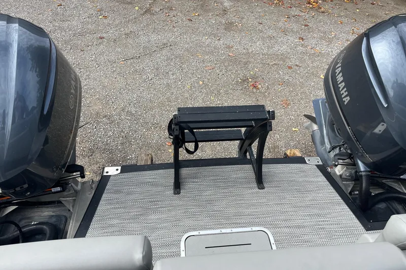 Slide: The Image of 2021 Bennington 27 QXFBWAX2 boat with dual Yamaha engines on a gravel surface. - 4