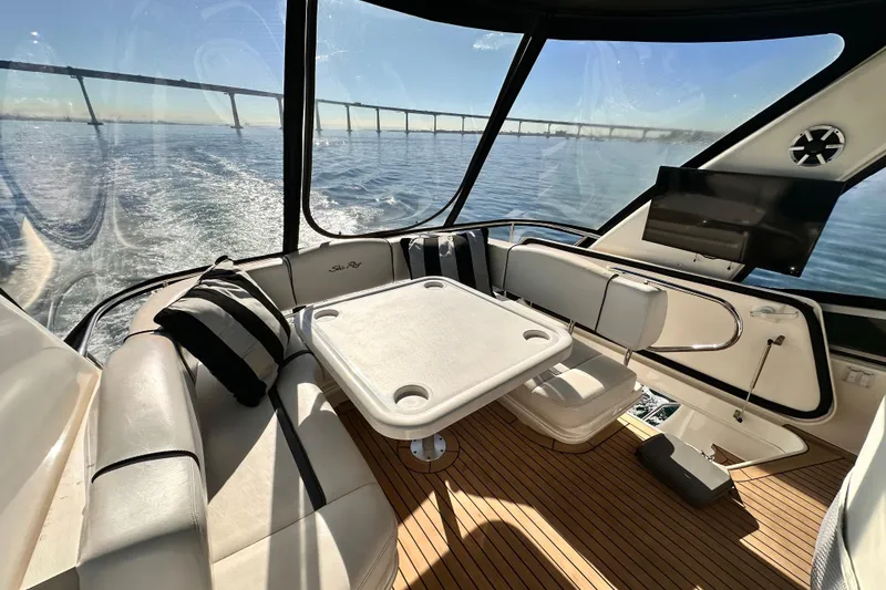 Slide: The Image of 2005 Sea Ray 420 Sedan Bridge interior with seating, table, and ocean view. - 6