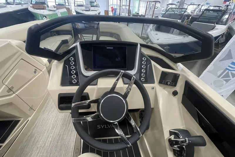 Slide: The Image of 2024 Sylvan G5 CLZ DC boat dashboard with modern steering and control panel. - 10