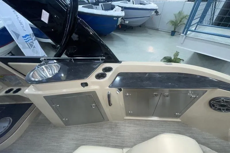 Slide: The Image of 2024 Sylvan G5 CLZ DC boat interior with sink, storage cabinets, and speaker. - 14