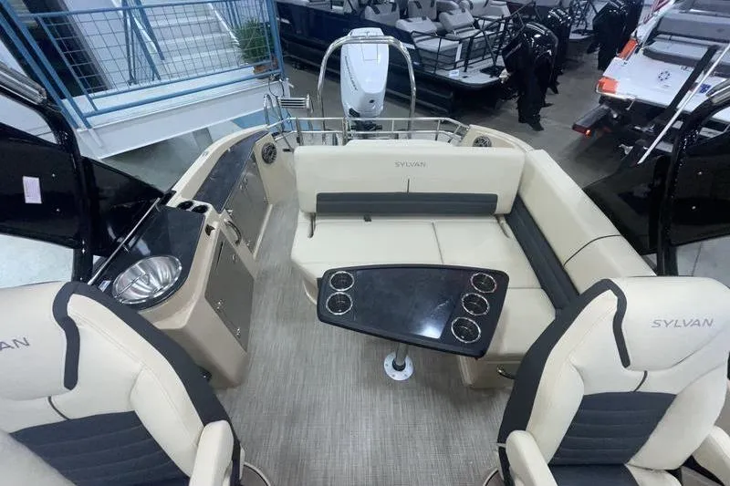 Slide: The Image of 2024 Sylvan G5 CLZ DC boat interior with beige seating and black table. - 17