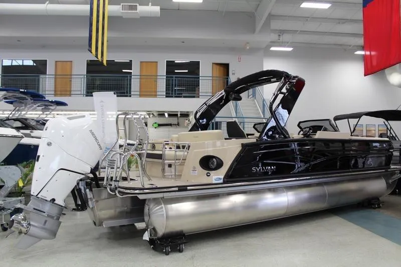 Slide: The Image of 2024 Sylvan G5 CLZ DC pontoon boat displayed indoors with powerful outboard motor. - 7