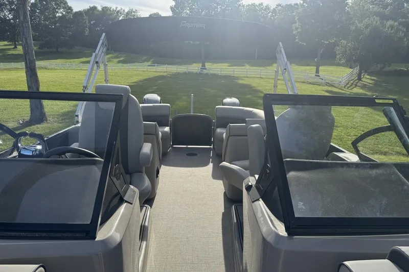 Slide: The Image of 2021 Premier 270 S-Series RF boat interior with seating and steering wheel, set in a grassy landscape. - 23