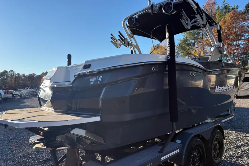 Slide: The Image of 2019 MasterCraft XStar boat on trailer, rear view, sunny day, autumn trees. - 4
