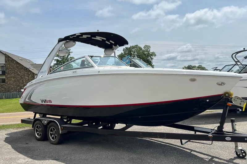 Slide: The Image of 2018 Cobalt R5 Surf boat on trailer, white and black design, parked outdoors. - 1