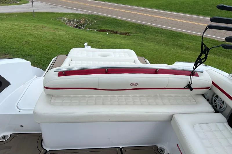 Slide: The Image of 2018 Cobalt R5 Surf boat with white and red seating, parked on grass. - 17