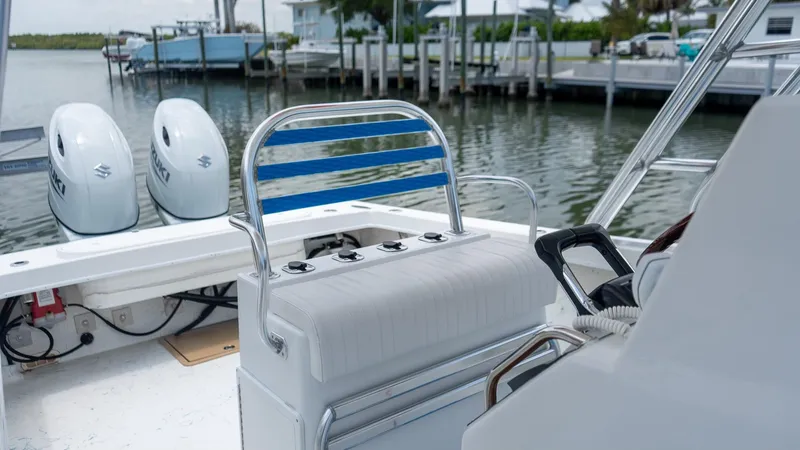 Slide: The Image of 2021 C-Hawk 29CC boat interior with dual engines, docked by waterfront homes. - 14