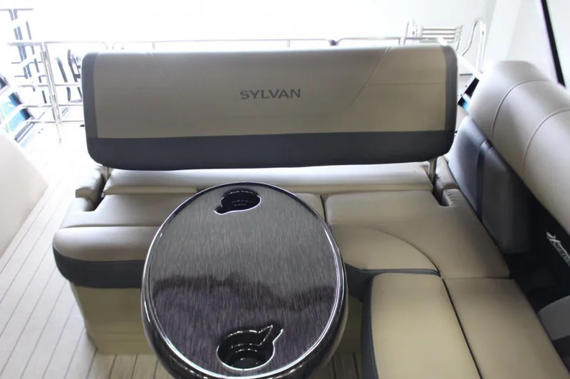 Slide: The Image of 2024 Sylvan Mirage X X3 boat interior with beige seating and round table. - 8