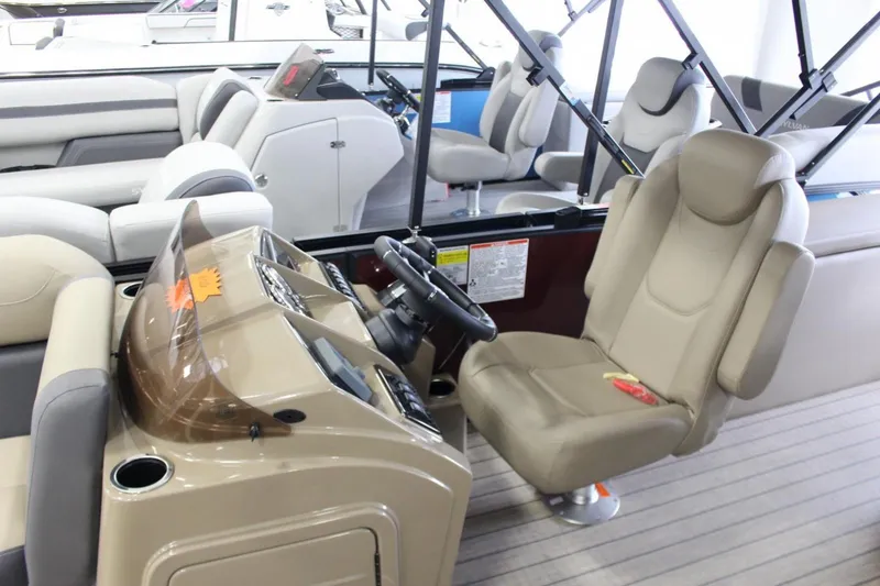 Slide: The Image of 2024 Sylvan Mirage X X3 boat interior with beige captain's chair and steering console. - 9
