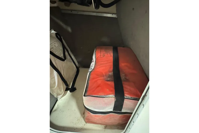 Slide: The Image of Storage compartment in a 2000 Bryant 214 Walk Through boat with red and white gear. - 10