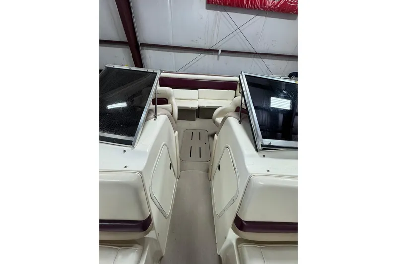 Slide: The Image of 2000 Bryant 214 Walk Through boat interior with seating and windshield in storage. - 6