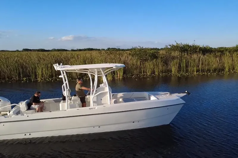 Slide: The Image of 1997 Sea Cat SL5 Cat boat cruising on a calm river with grassy banks. - 10