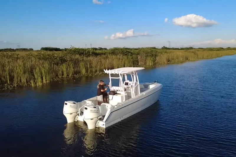 Slide: The Image of 1997 Sea Cat SL5 Cat boat cruising on a serene river with lush greenery. - 13