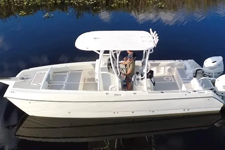 Slide: The Image of 1997 Sea Cat SL5 Cat boat on calm water, featuring dual engines and a center console. - 2