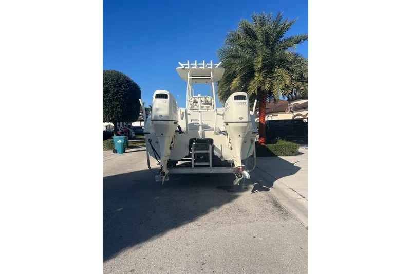 Slide: The Image of 1997 Sea Cat SL5 Cat boat with dual outboard motors, parked near palm trees. - 31