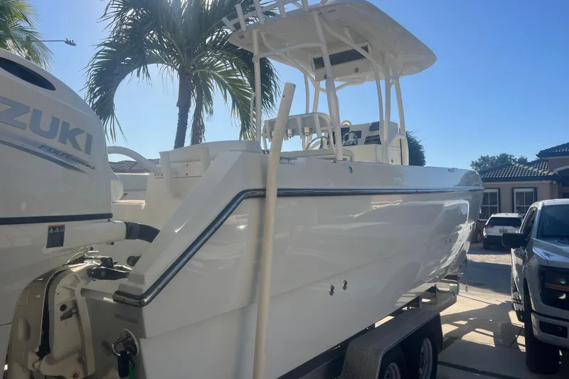 Slide: The Image of 1997 Sea Cat SL5 Cat boat with Suzuki engine, parked under palm trees. - 32