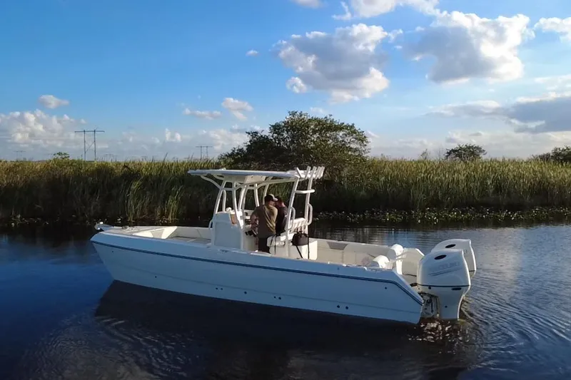 Slide: The Image of 1997 Sea Cat SL5 Cat boat cruising on a calm river under a blue sky. - 5