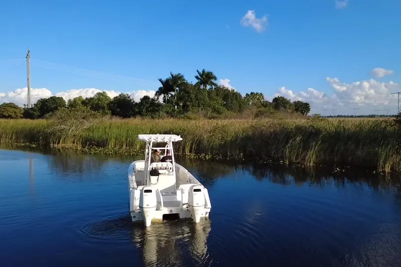 Slide: The Image of 1997 Sea Cat SL5 Cat boat navigating a serene river with lush greenery. - 6