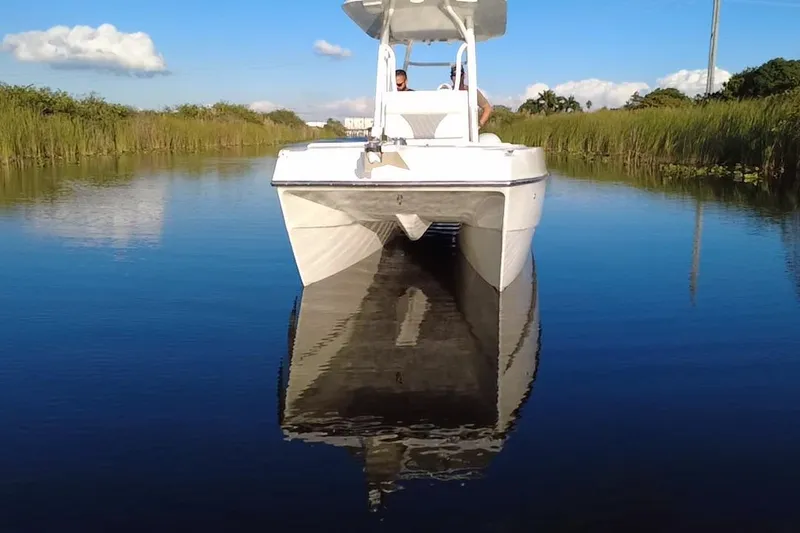 Slide: The Image of 1997 Sea Cat SL5 Catamaran cruising on a calm, narrow waterway under a clear sky. - 7