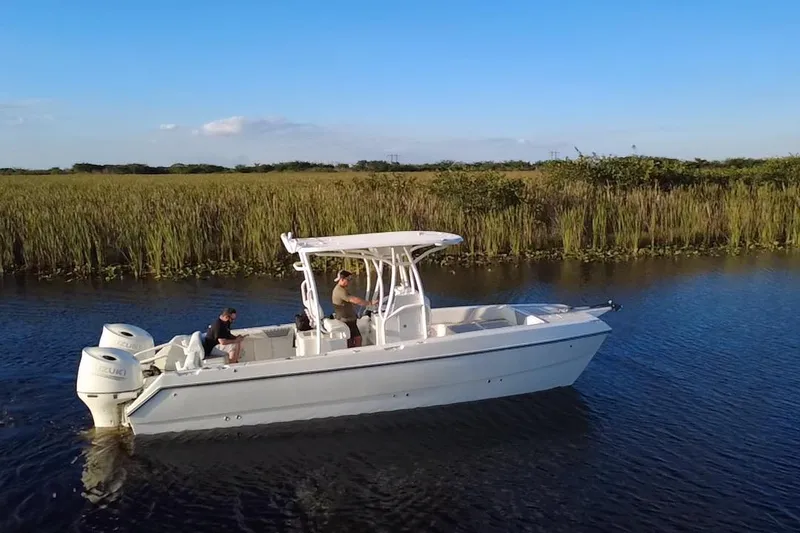 Slide: The Image of 1997 Sea Cat SL5 Cat boat cruising on a calm river with grassy banks. - 14