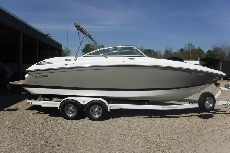 The Image of 2010 Cobalt 242 boat on trailer, parked outdoors under clear sky. - 1