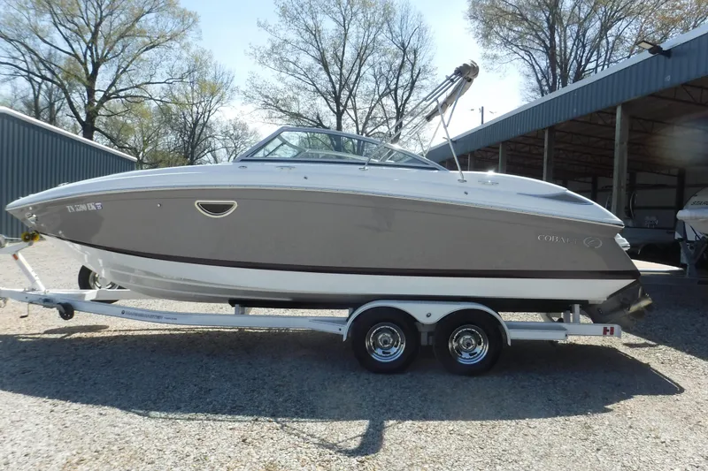 Slide: The Image of 2010 Cobalt 242 boat on trailer, parked outdoors near storage facility. - 17