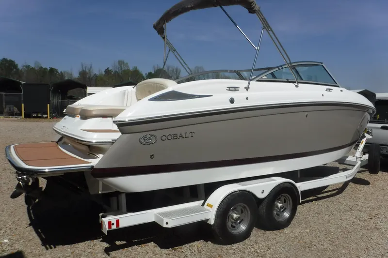 Slide: The Image of 2010 Cobalt 242 boat on trailer, white exterior, parked outdoors. - 21