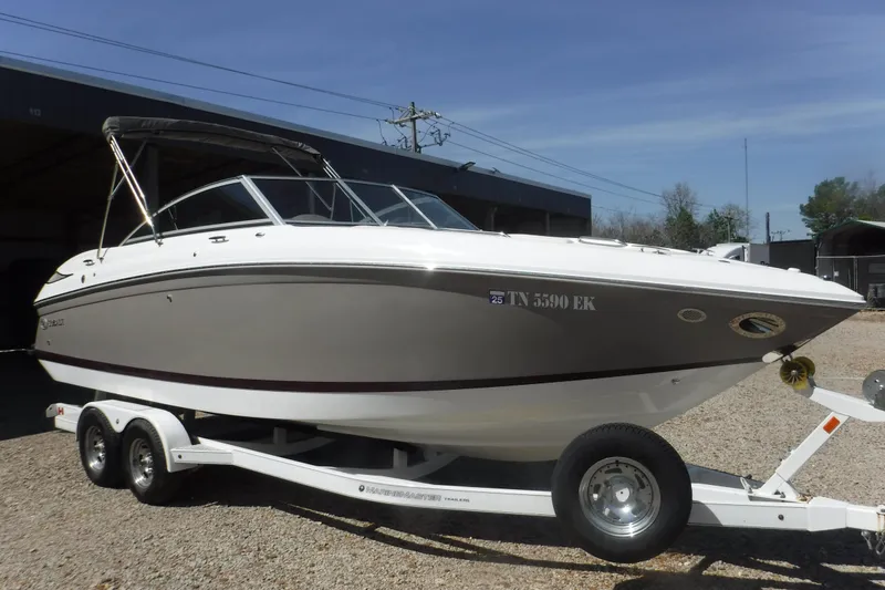 Slide: The Image of 2010 Cobalt 242 boat on trailer, parked outdoors under clear sky. - 22
