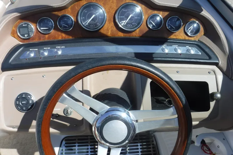 Slide: The Image of Steering wheel and dashboard of 2010 Cobalt 242 boat with wood accents and gauges. - 5