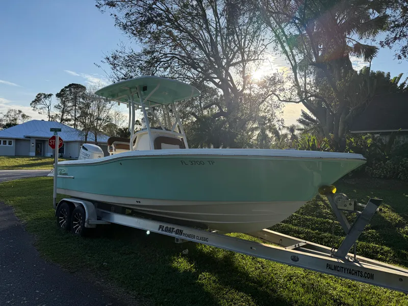 The Image of 2023 Pioneer 220 Bay Sport boat on trailer, parked outdoors in a sunny setting. - 0