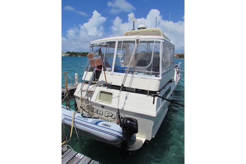 Slide: The Image of 1992 Hatteras 40 Motor Yacht docked, featuring clear skies and turquoise waters. - 1