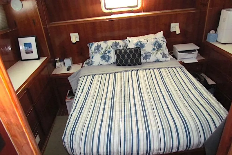 Slide: The Image of Cozy bedroom interior of 1992 Hatteras 40 Motor Yacht with striped bedding and wooden cabinetry. - 17