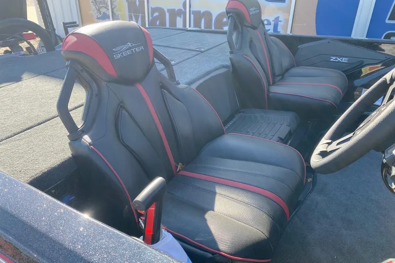 Slide: The Image of 2026 Skeeter ZXE20 boat interior with black and red seats, steering wheel, and branding. - 9