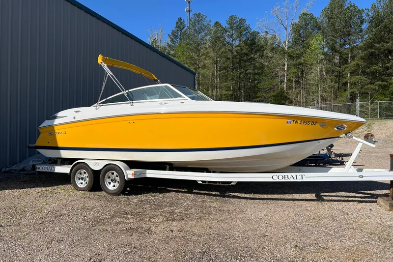 The Image of 2008 Cobalt 252 boat in vibrant yellow on a trailer, parked outdoors. - 0
